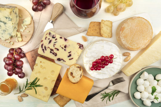 Various types of cheese with wine on a light background