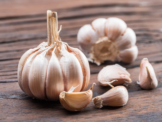 Garlic bulb and garlic cloves on the wooden table.
