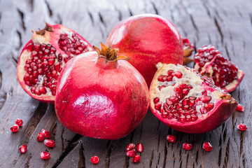 Ripe pomegranate fruits on the wooden background.