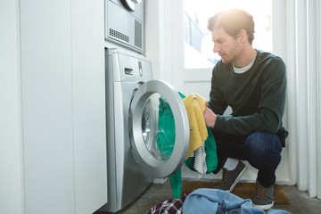 Man putting clothes in washing machine