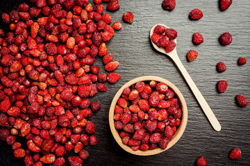 red strawberries in bowl on a wooden background