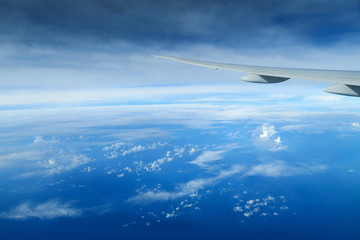 Aircraft wing above the clouds, view from the airplane window