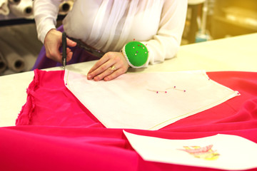 Seamstress, tailor with scissors. Cutting. Needles. Cutting process