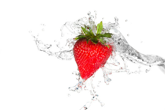 Water splashing on a strawberry against a white background