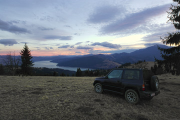 Fototapeta na wymiar off road car in the mountain landscape and lake