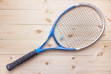 Tennis racket and ball on the wooden background top view