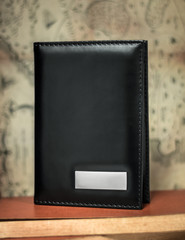 Black passport wallet on vintage background. Template of leather wallet for your design.