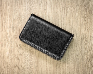 Black leather card holders on wooden background. Top view of Leather wallet for keep your money.
