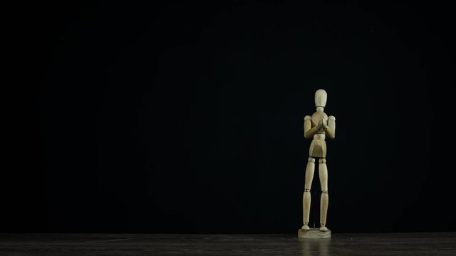 Stopmotion wooden figure dummy in studio on black background