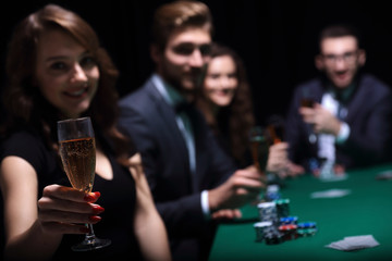 fashion woman with glasses of wine,sitting at a table in a casino