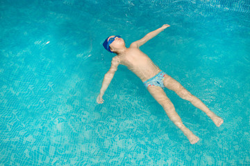 Little boy swimming in the pool , having fun in swimming pool.
