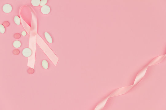 Pink tape as symbol of women illness mammary cancer with medicine pills  drugs isolated on pink background