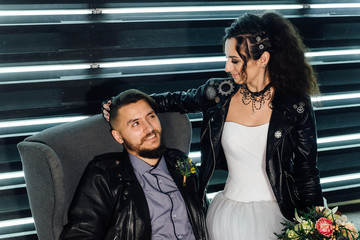 Wedding in the style of rock. Rocker or Biker wedding. Guys with stylish leather jackets. It's a rock'n'roll baby. Sweet couple in a photo studio. Steep shooting with mirrors and lamps.