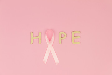 Wooden letters "Hope" with pink tape as symbol of women illness mammary . cancer isolated on pink background