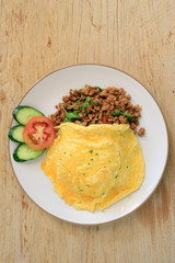 Top view Close up Rice topped with stir fried minced pork and basil on wooden table