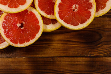 Sliced grapefruits on wooden table. Top view, copy space