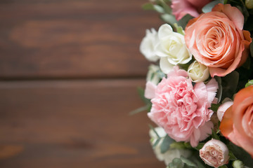 Delicate bouquet of roses, eustomams and carnations with eucalyptus branches on a dark wooden background