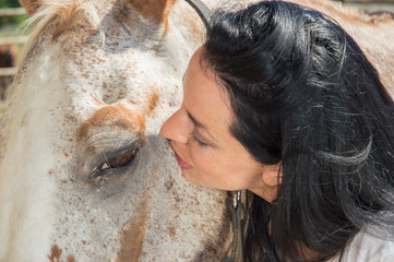 Naklejka premium Black haired female watching deeply in horse eye like it is a universe 