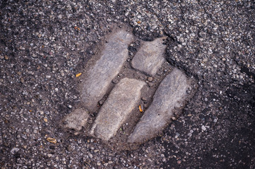 Cobblestones Exposed in Asphalt - Pothole