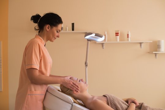 Beautician Giving Face Massage To Female Customer