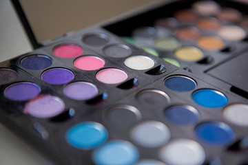 Multicolored eyeshadow and lipstick in a pallet close up