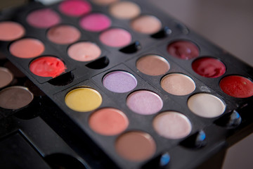 Multicolored eyeshadow and lipstick in a pallet close up