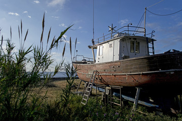 Fototapeta na wymiar An ancient wooden fishing boat taken to the shore on Stromboli Island in Italy