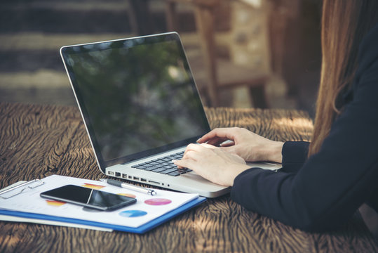 Side view of young smart female using laptop with sunlight. Working anywhere anytime anyplace.