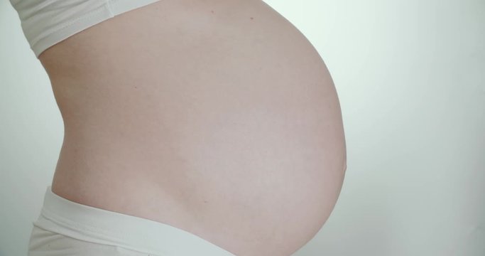 the belly of a pregnant woman wiggling child, close up
