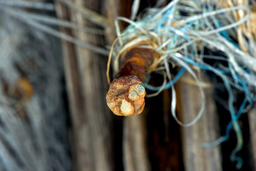 Rusty nail with leftovers of fishing net