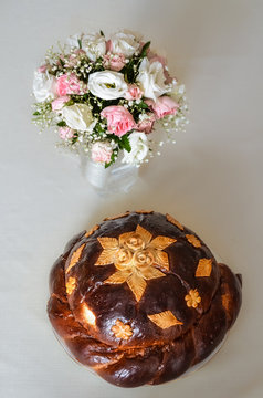 Traditional Ukrainian wedding bread called korovai or karavai with decorations and rose flower bouquet