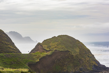 Misty and Foggy Oregon Coast cliffs and forests with hill and road