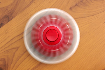 Two spinners on a wooden background. Red and white spinners. Toys