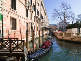 Fototapeta na wymiar the gondola, a traditional Venetian boat, moored in a narrow canal bordering ancient palaces