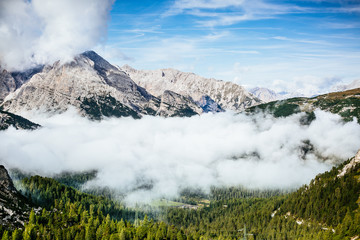 Fototapeta na wymiar Nebliges Tal umgeben von Bergen in den Dolomiten 