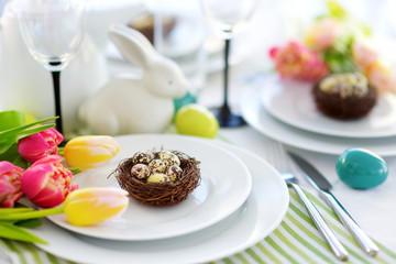 Beautiful table setting with crockery and flowers for Easter celebration