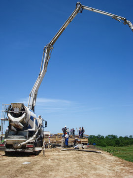 Workers is pouring cement into a foundation