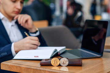 Businessman works in his workplace with notebook, laptop and makes a business plan. Cryptocurrency...