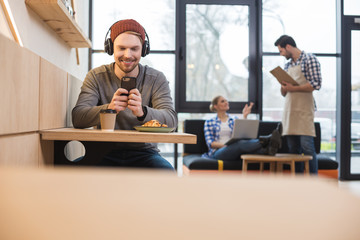 Pleasant positive man sitting at the cafe table