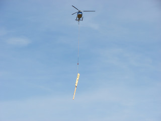 Helicopter take off and carrying wooden beams