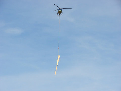 Helicopter take off and carrying wooden beams