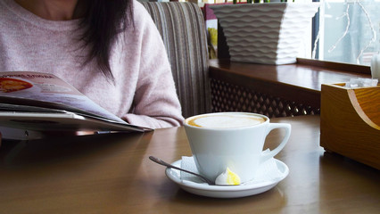 Girl drinking coffee in a cafe.