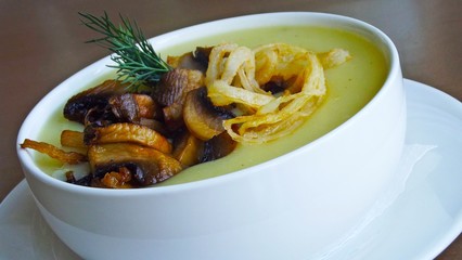 Delicious potato cream soup with fried onions and mushrooms.