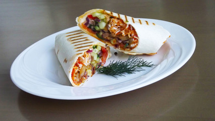 Tasty vegetables in pita bread on a white plate.