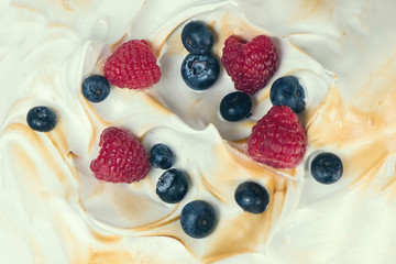 The texture of the meringue cake with blueberries and raspberries