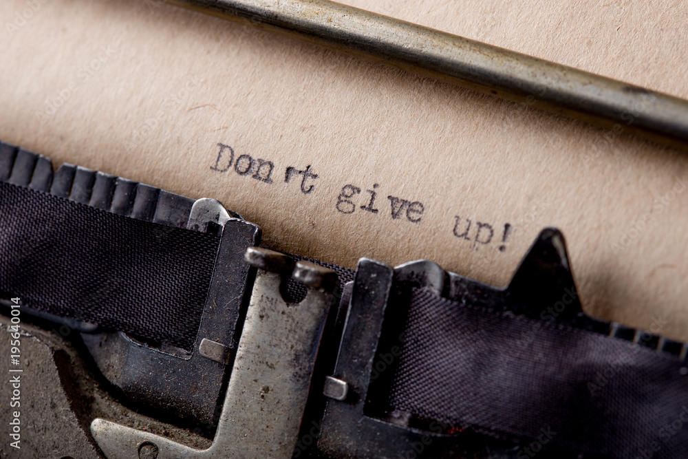 Fototapete dont give up - text message on the typewriter close-up