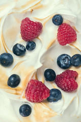 The texture of the meringue cake with blueberries and raspberries