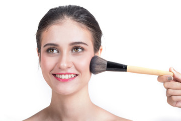 Young beautiful woman applying make-up by make-up artist isolated on white.