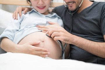 Obraz premium In Selective Focus Of Happy Family Checking New Baby In The Morning.Close Up Of A Beautiful Happy Pregnant Woman With Big Belly. Pregnancy And Motherhood Moment People And Expectation Concept.