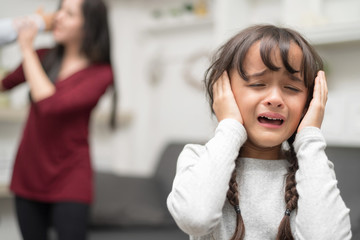 Domestic violence and Family conflict concept. Sadness little girl against blured of mother...